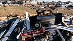 A Radio Flyer wagon lies among debris along Moss Creek Avenue Tuesday, Dec. 14, 2021, in Bowling Green, Ky.