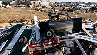 A Radio Flyer wagon lies among debris along Moss Creek Avenue Tuesday, Dec. 14, 2021, in Bowling Green, Ky.