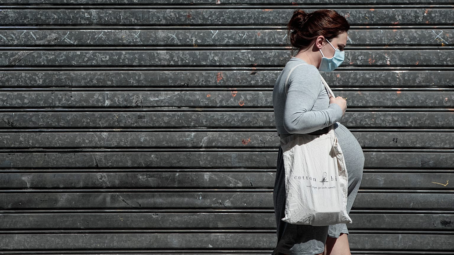 A pregnant woman walks in the streets in Paris on May 12, 2020 .