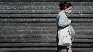 A pregnant woman walks in the streets in Paris on May 12, 2020 .