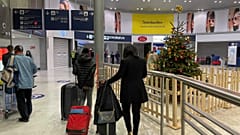 Arriving passengers walk by a Christmas tree at Paris Charles de Gaulle airport terminal E Tuesday Dec. 22, 2020. 