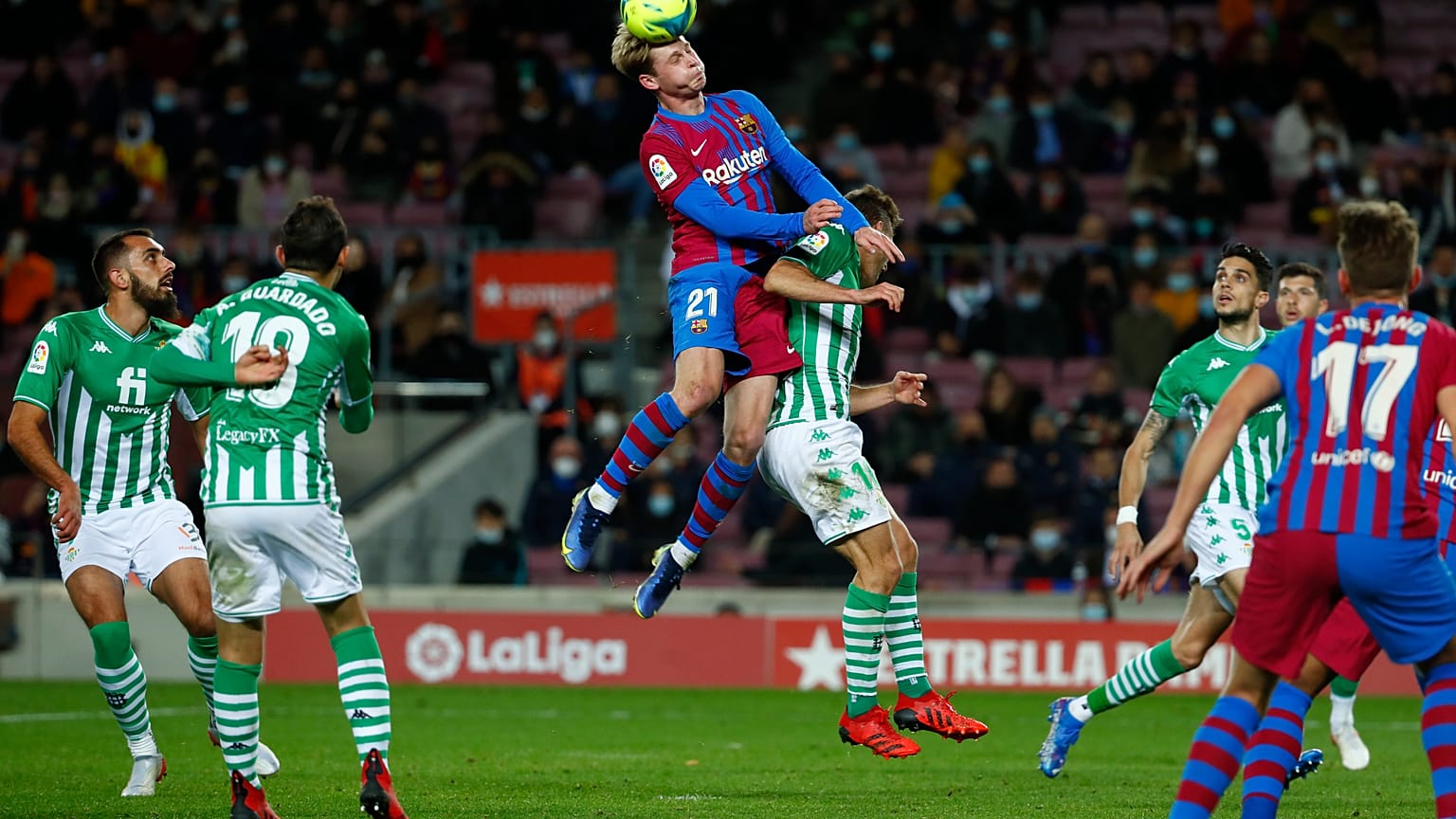 Barcelona's Frenkie de Jong, top, goes for a header with Sergio Canales at a match between Barcelona and Real Betis at Camp Nou 