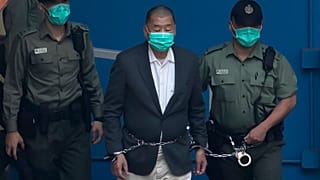 Jimmy Lai who founded the Apple Daily, is escorted by Correctional Services officers to get on a prison van before appearing in a court in Hong Kong. 