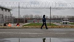 A prison guard inspects inmates at the detention centre of Lipljan.