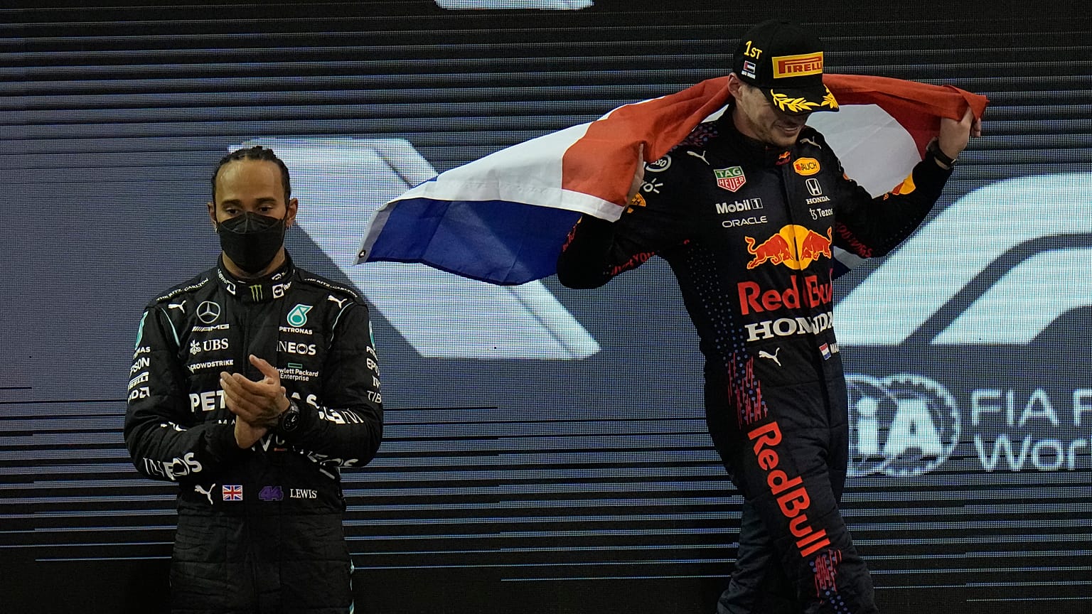 Lewis Hamilton (L) applauds as Red Bull driver Max Verstappen celebrates his victory in Abu Dhabi.