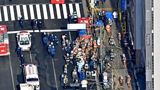Policemen and firefighters gather near a building where a fire broke out in Osaka, western Japan, Dec. 17, 2021. 