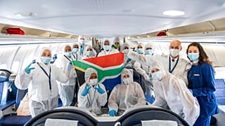 Die Besatzung eines "South African Airlines" Fluges posiert nach ihrem vorerst letzten Flug aus Kapstadt in Schutzkleidung in Frankfurt, 24.04.2020.