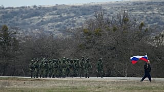 Simferopol kentinde Rus askerleri ve Rus bayrağı taşıyan bir sivil (arşiv) 