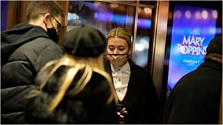ضابطة في الأمن البريطاني تتحقق من الشهادة الصحية المتعلقة بـ"كوفيد-19" عند بوابة الدخول إلى أحد المسارح في العاصمة لندن، الجمعة 17 ديسمبر 2021