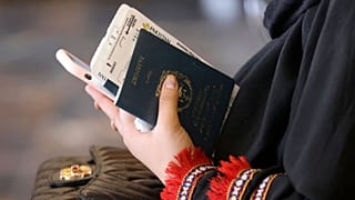 زنی که پاسپورت حکومت قبلی (جمهوری اسلامی افغانستان)‌ را در دست دارد. 