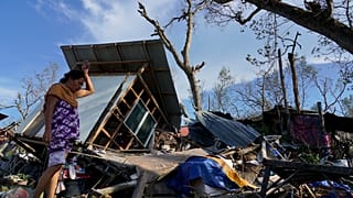 Una residente rescata partes de su casa dañada por el tifón Rai en Talisay, provincia de Cebú, en el centro de Filipinas, el 18 de diciembre de 2021.