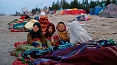 Afgán gyerekek takaróba bugyolálva egy táborban