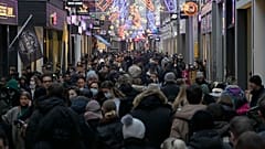 Crowds of people walk down a street on the last Saturday before Christmas in Amsterdam, the Netherlands