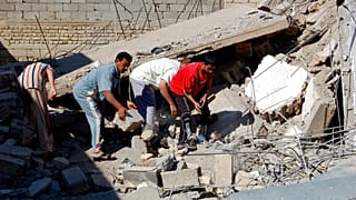 صورة من الارشيف- أشخاص يبحثون عن جثث وسط أنقاض منزل دمر في غارة جوية في الرمادي، العراق