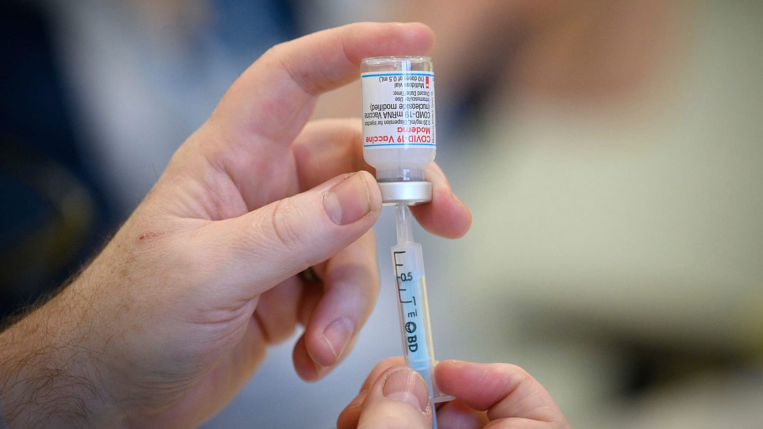 Medical staff and volunteers prepare shots of the Moderna Covid-19 vaccine