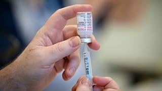 Medical staff and volunteers prepare shots of the Moderna Covid-19 vaccine