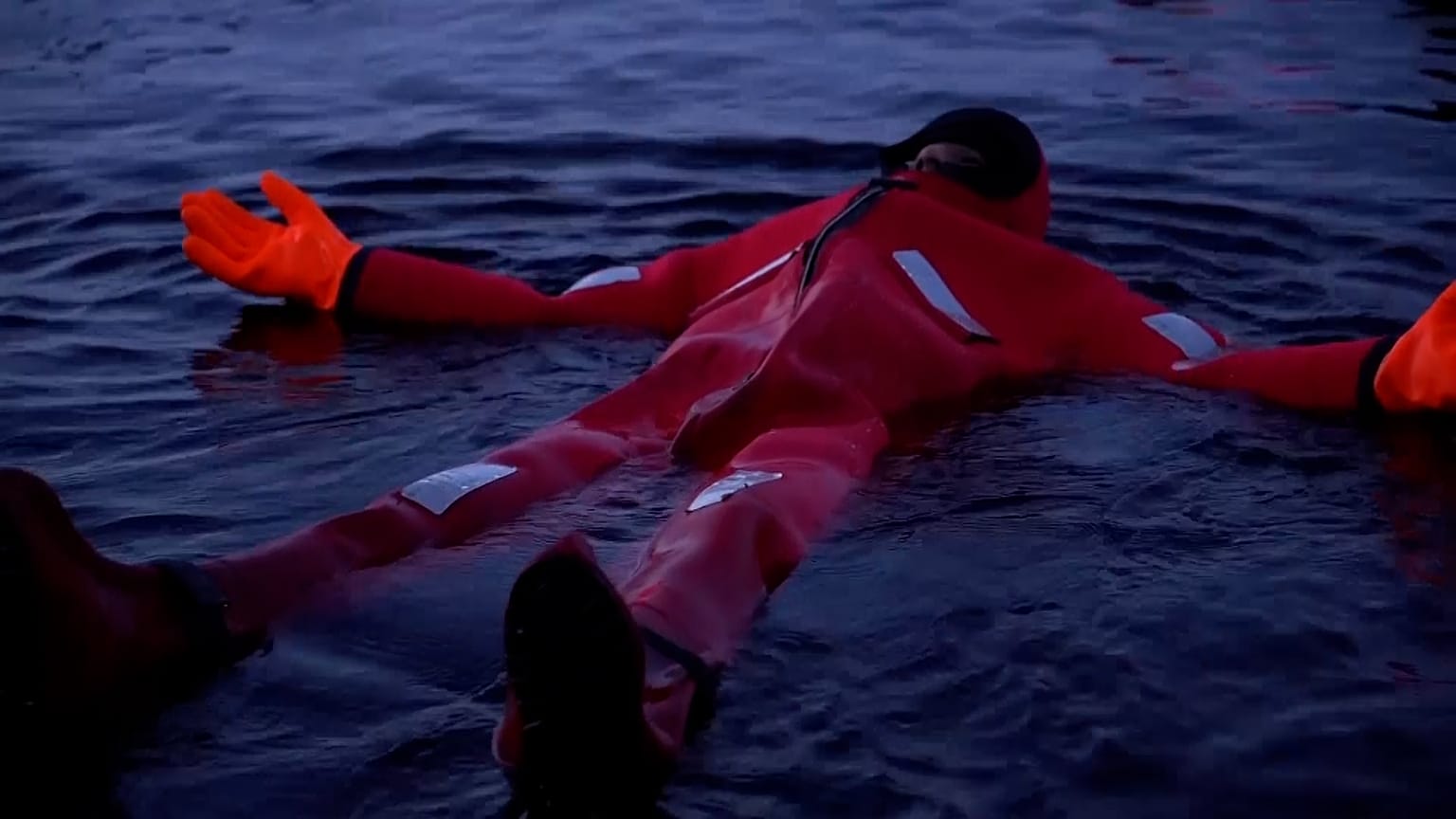 Swimmers stay warm and dry whilst floating in a frozen lake
