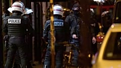 Policemen and members of the French Research and Intervention Brigade (BRI) unit stand outside a hardware shop, where two women are held hostage in Paris, Dec. 20, 2021.