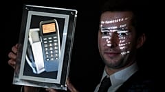 Maximillien Aguttes, de la maison de vente aux enchères Aguttes, présente un écran montrant un téléphone avec le tout premier SMS au monde