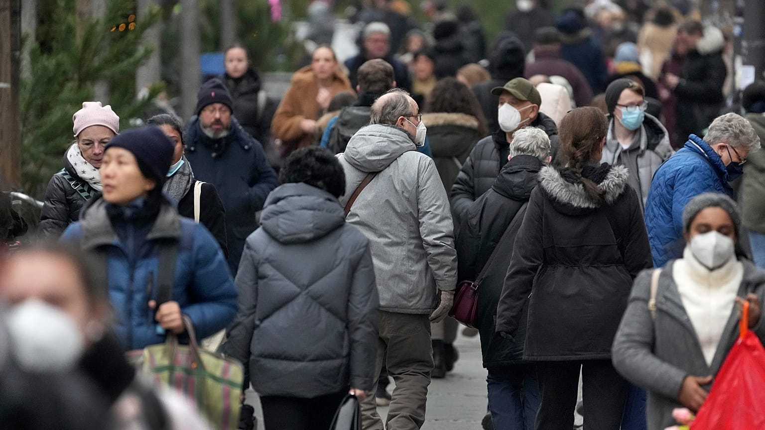 People walk on a shopping road in Berlin, Germany, Tuesday, Dec. 21, 2021