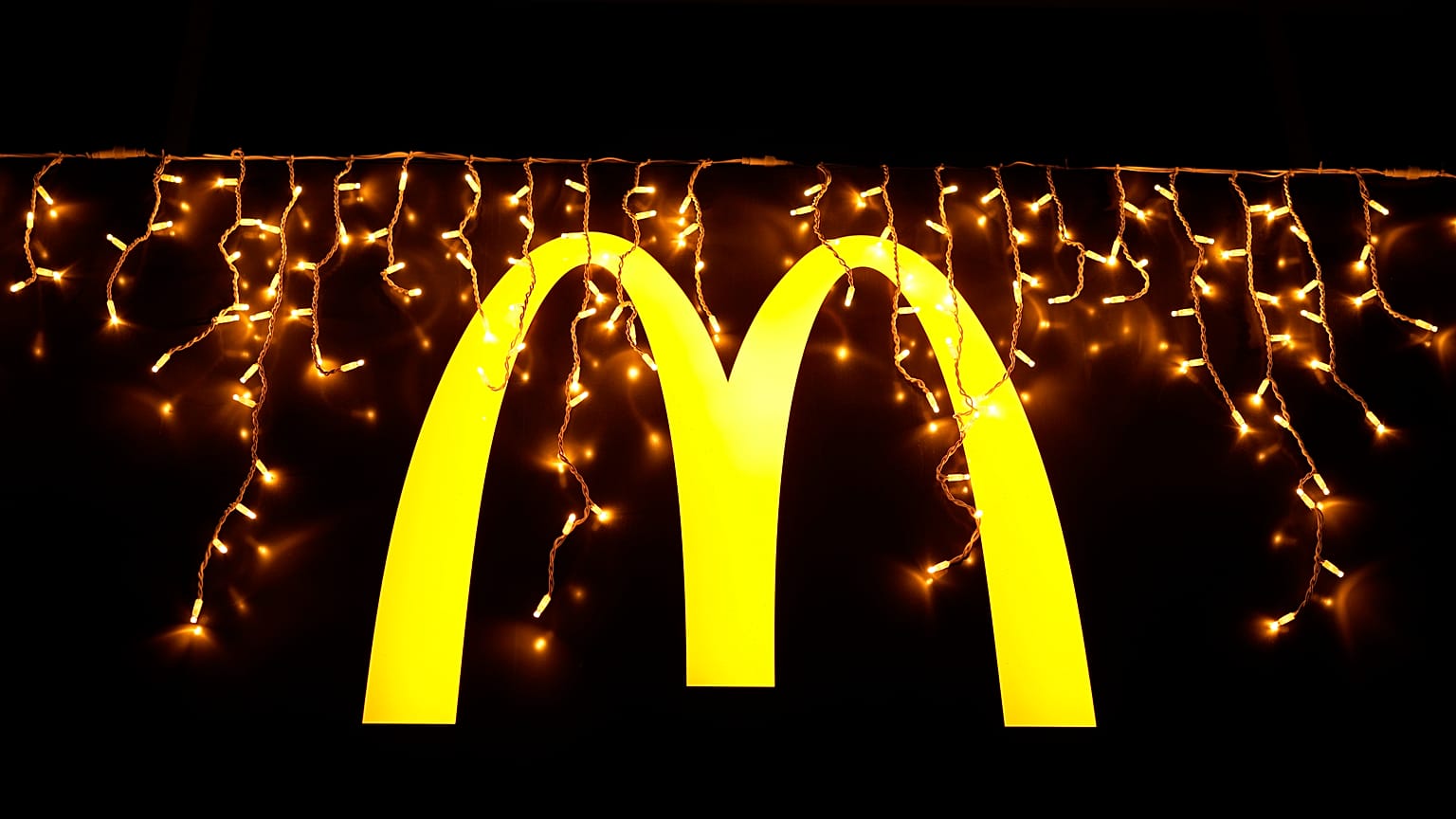 Christmas lights are hung above the logo outside a McDonald's restaurant in Lisbon, Dec. 14, 2021.