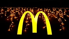 Christmas lights are hung above the logo outside a McDonald's restaurant in Lisbon, Dec. 14, 2021.