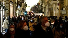 People crowd via del Corso shopping street in Rome, 21 December 2021.