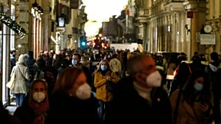People crowd via del Corso shopping street in Rome, 21 December 2021.