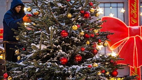 A worker fixes decorations on a Christmas tree in downtown Moscow on December 15, 2021.