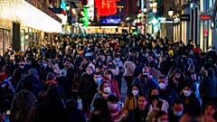 Personas con mascarillas para frenar la propagación del coronavirus caminan en el centro de Madrid, España, el martes 21 de diciembre de 2021.