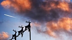 Weihnachtsdekoration und im Hintergrund Kondensstreifen eines Flugzeugs über Michigan: Welche Auswirkungen wird die neue 5G-Technik auf die Technik von Flugzeugen haben?
