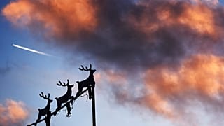 Weihnachtsdekoration und im Hintergrund Kondensstreifen eines Flugzeugs über Michigan: Welche Auswirkungen wird die neue 5G-Technik auf die Technik von Flugzeugen haben?