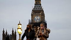 People walk past the Big Ben clock at the Houses of Parliament in central London on December 16, 2021 as some scaffolding is removed with restoration project nearing its end.