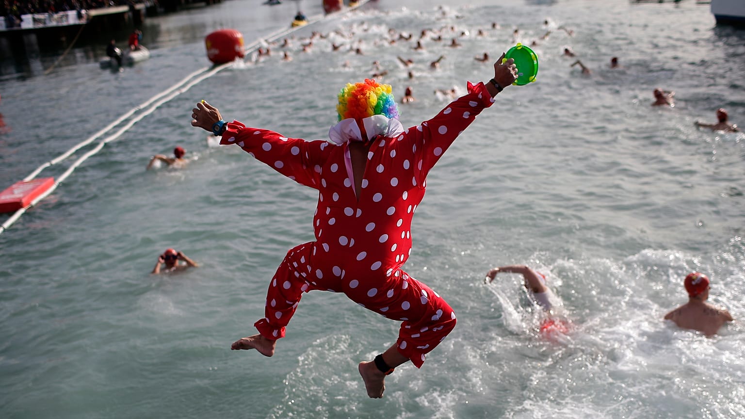 Persona vestida de payaso salta al Mediterráneo en Barcelona mientras participa en la Copa Nadal, una tradicional competición de natación que se celebra cada 25 de diciembre.