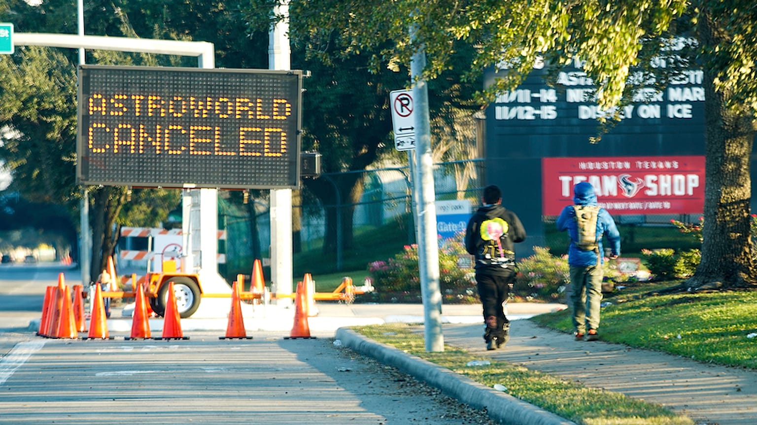 People walk past a sign announcing Astroworld is canceled outside NRG in Houston on Nov. 6, 2021. 
