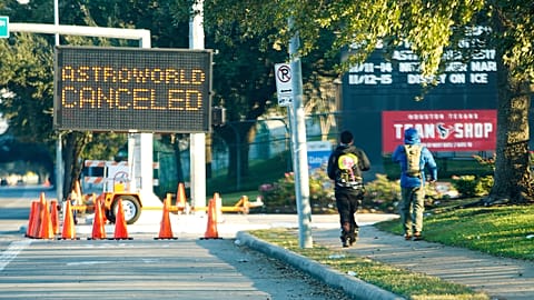 People walk past a sign announcing Astroworld is canceled outside NRG in Houston on Nov. 6, 2021. 