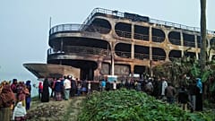 Villagers look at a burnt-out ferry after it caught on fire killing at least 37 people in Jhakakathi, 250 kilometres south of Dhaka, on December 24, 2021.