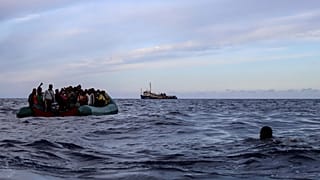 A migrant who was aboard a precarious rubber boat with others jumps to the water as they are rescued around 35 miles away from Libya, in Libyan SAR zone, Oct. 18, 2021