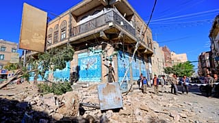 يمنيون يتفقدون ما خلفته الغارة الجوية للتحالف بقادة السعودية على العاصمة صنعاء ليل الجمعة. 24/12/2021