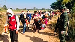 Thai soldiers receive Myanmar villagers arriving in Thailand after fleeing clashes between Myanmar troops and an ethnic Karen rebel group in Mae Sot, Thailand