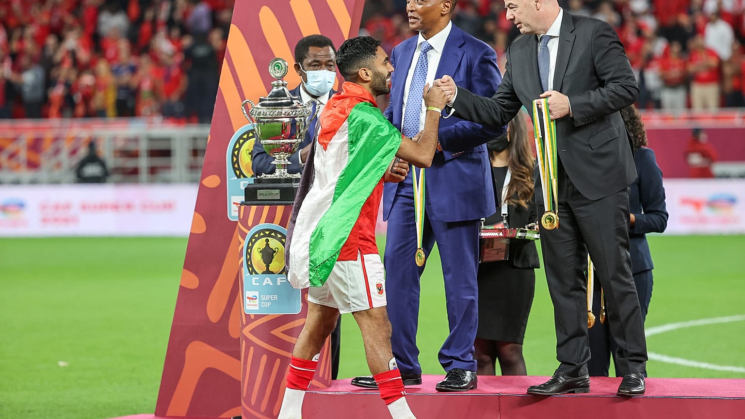 لاعب الأهلي المصري حسين الشحات يتوشح بعلم فلسطين خلال تكريمه من رئيس الفيفا بعد فوز الاهلي على الرجاء المغربي في كأس السوبر الإفريقي بالدوحة