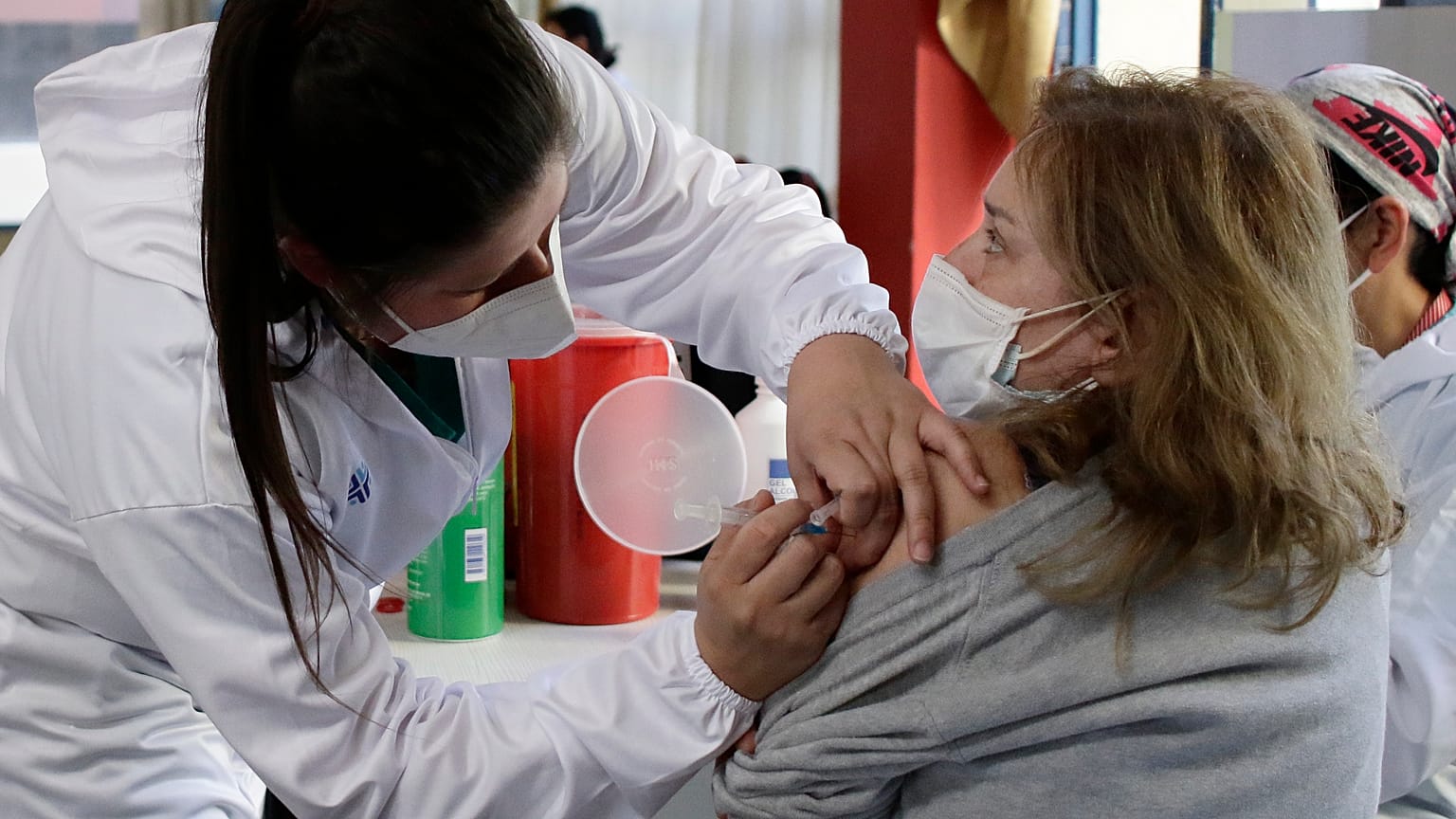 Une femme se fait vacciner à Quito en Equateur, premier pays à mettre en œuvre la vaccination obligatoire 