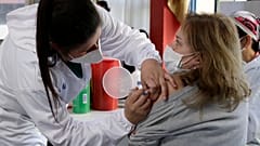 Une femme se fait vacciner à Quito en Equateur, premier pays à mettre en œuvre la vaccination obligatoire 