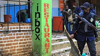 Police officers inspect the scene of a bomb explosion in Beni, eastern Congo