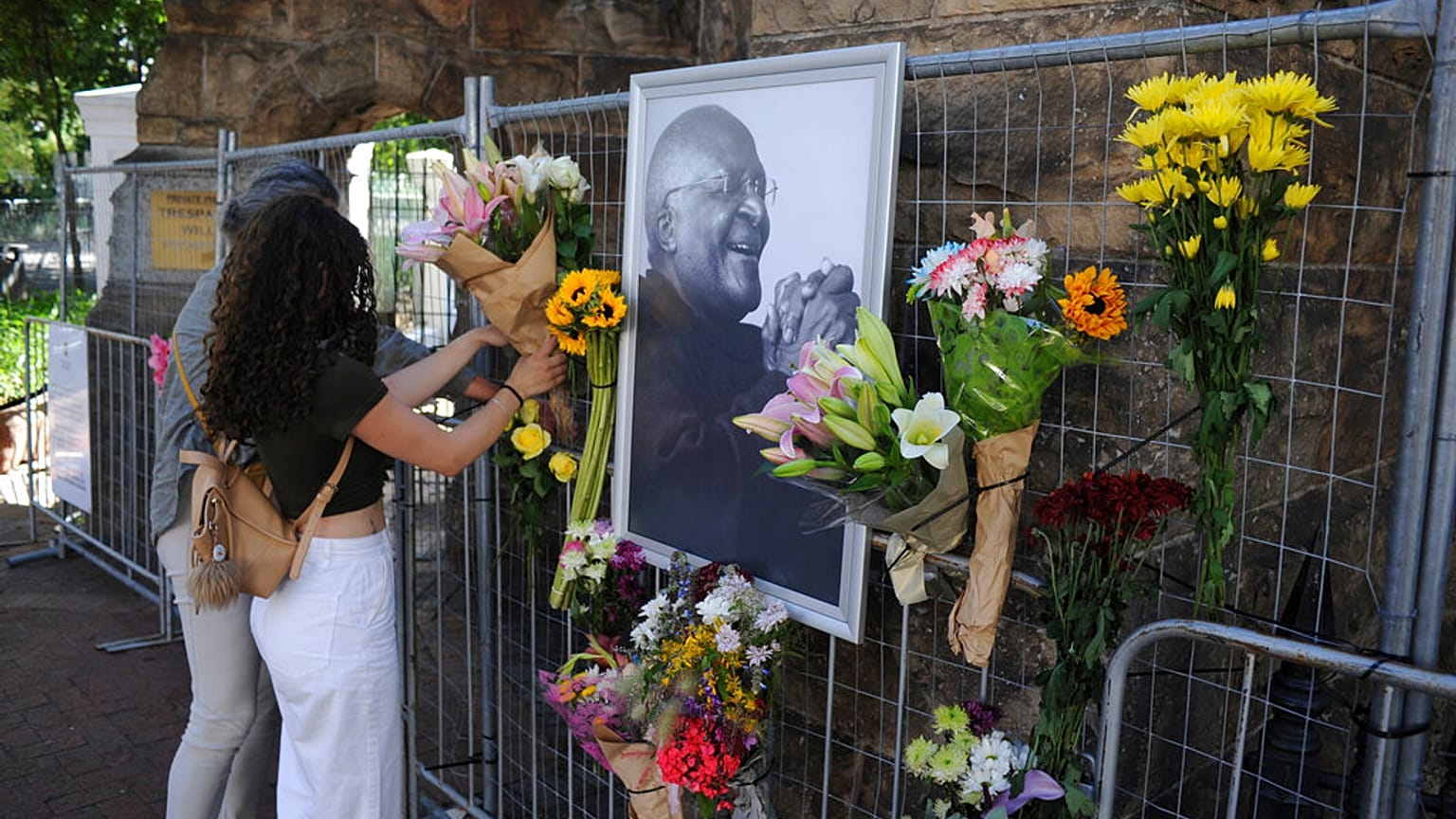 Des passants rendent hommage à Desmond Tutu, à l'extérieur de la Cathédrale Saint-Georges du Cap, Afrique du sud, le 26 décembre 2021