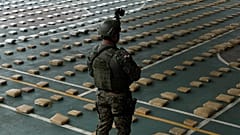 عنصر من الشرطة البنمية يحرس مئات من حزم الماريجوانا التي تم ضبطها في غامبوا، بنما. 
