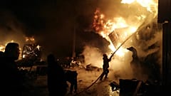 Die Feuerwehr versucht die brennenden Container zu löschen