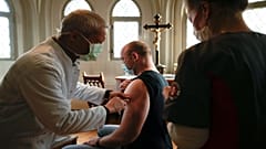 A doctor vaccinates a man against coronavirus inside the St. Petri church in the center of Chemnitz, Germany, Dec. 12, 2021.