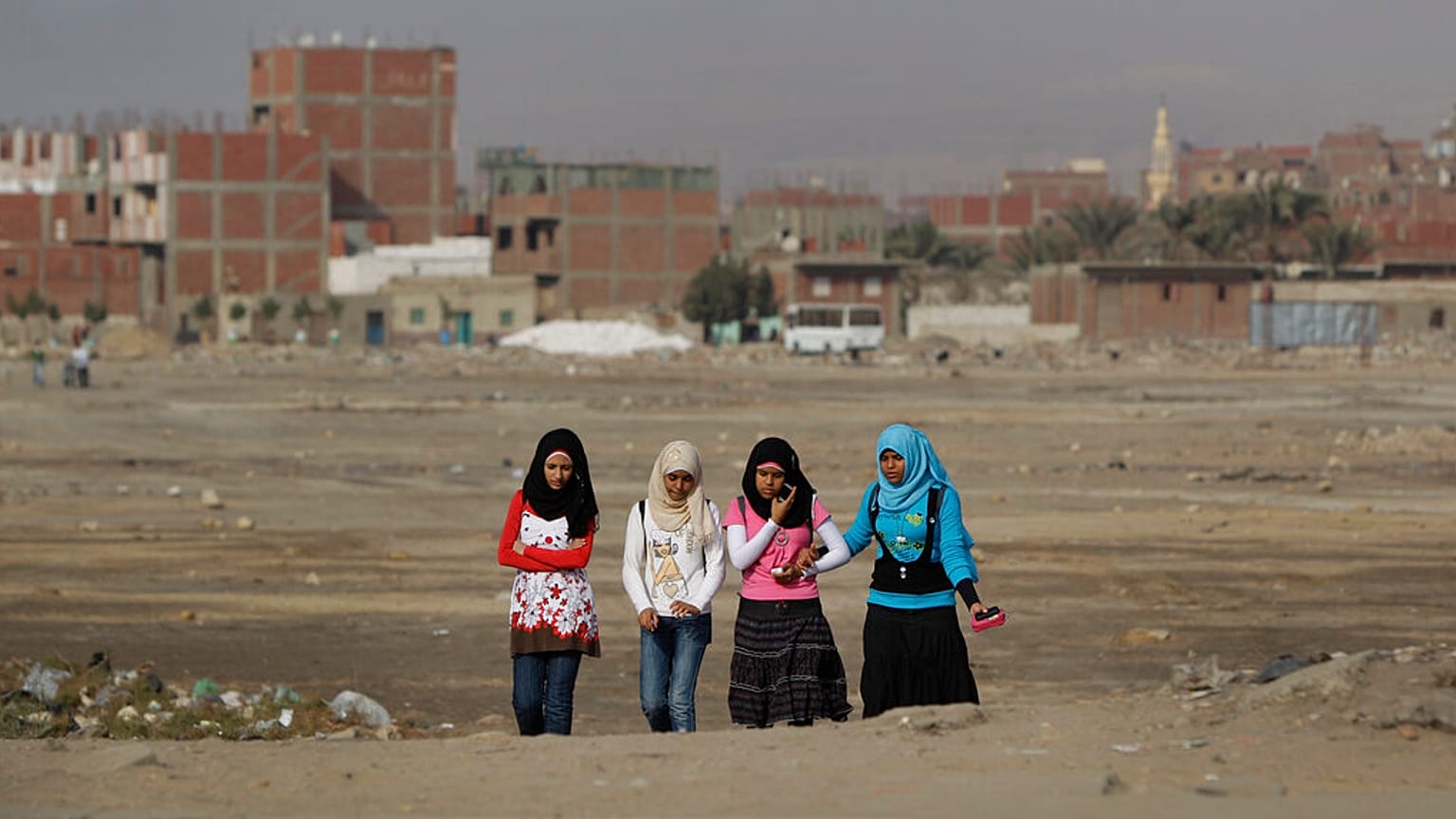 فتيات مصريات يمشين عبر أرض نفايات في حي حلوان الذي تقطنه الطبقة العاملة في القاهرة، مصر، الخميس 27 يناير 2011.