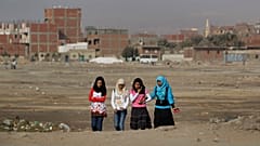 فتيات مصريات يمشين عبر أرض نفايات في حي حلوان الذي تقطنه الطبقة العاملة في القاهرة، مصر، الخميس 27 يناير 2011.